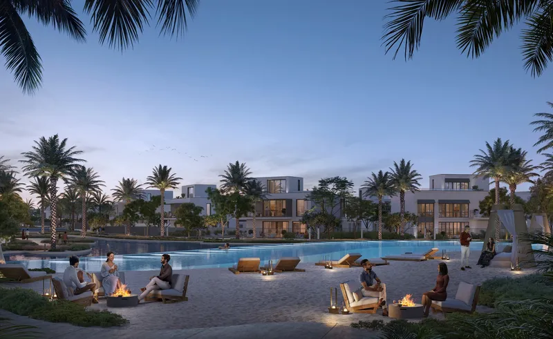 Render of a sandy lagoon beach with fire pits and loungers at dusk, with villas behind