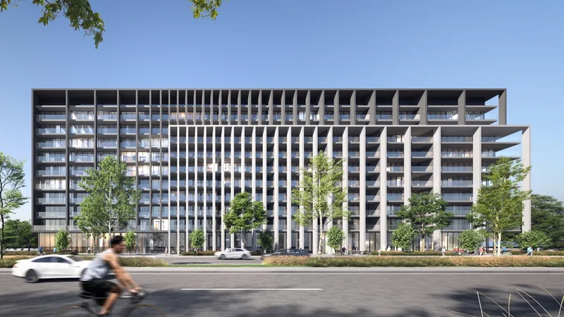 Render of the Nesba 2 apartment building at Aljada, Sharjah, with a dark grid facade and white fins, seen across a tree-lined road