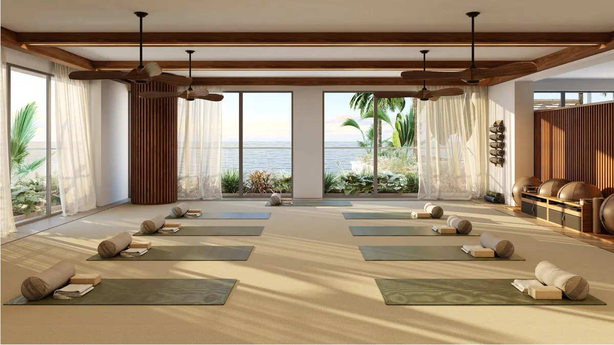 Yoga room with mats, timber ceiling fans and windows to the sea at Nobu Residences Abu Dhabi