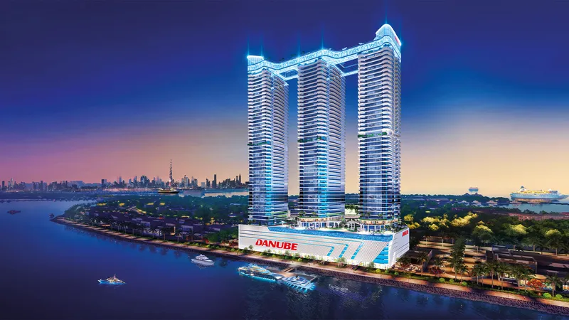 Oceanz by Danube towers at night with the Dubai skyline behind