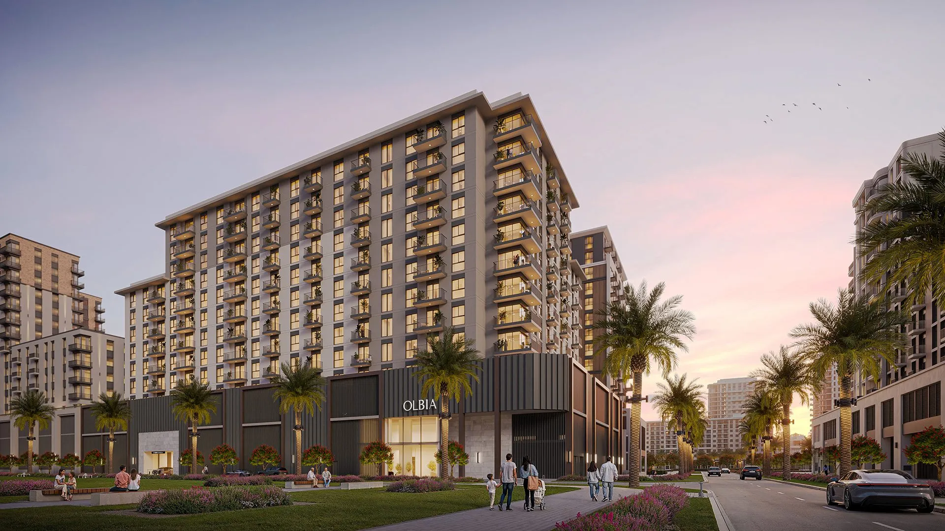 Render of Olbia by Nshama at dusk, a pale apartment block with balconies above a dark podium, beside a landscaped walkway with palm trees in Town Square