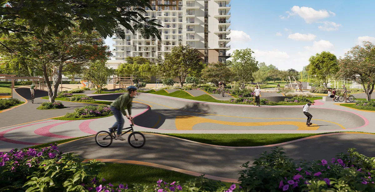 Render of cyclists and skaters on the pump track in Hillside Park with Parkwood behind