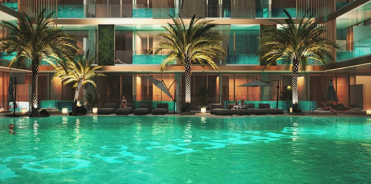Render of the lagoon pool lit at night, with palm trees and sun loungers