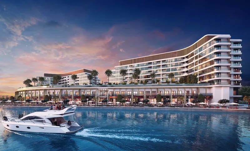 Pearlside Marina Residences at dusk with the waterfront shops lit along the canal