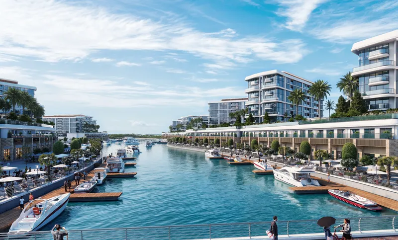 The marina canal at Sobha Siniya Island with boats moored along both promenades and residential buildings behind