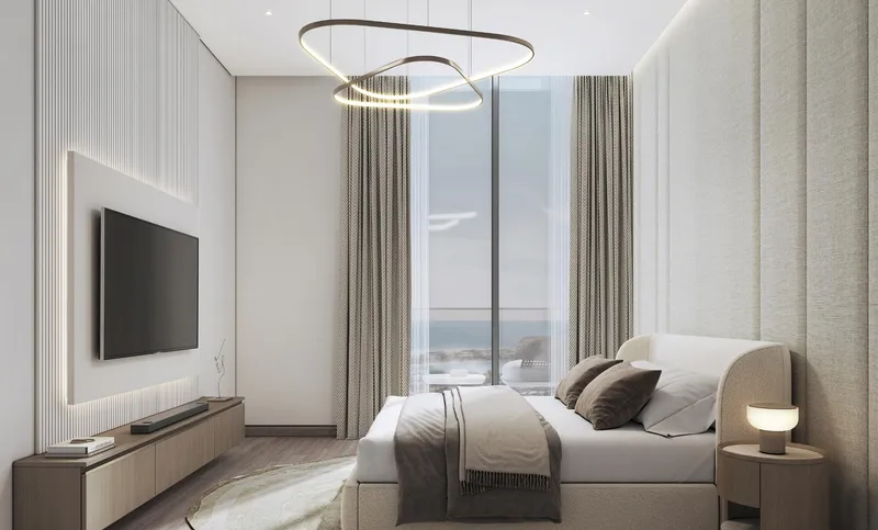 Bedroom with a sea-view window and wall-mounted television at Pristine Beach Residences
