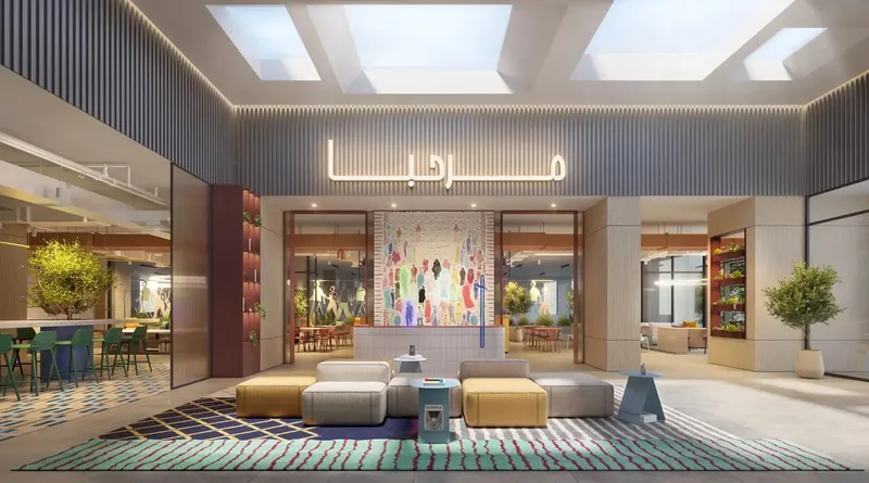Lobby lounge with skylights, colourful seating and an art wall at Rove Home Downtown Dubai