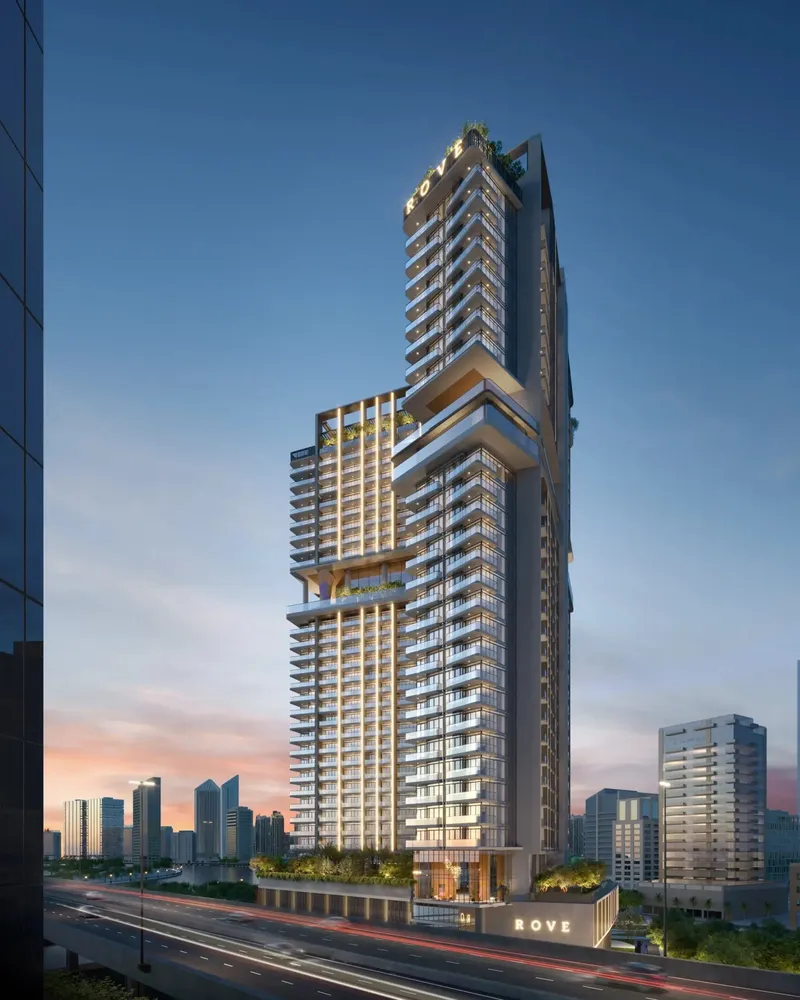 Rove Home Marasi Drive tower at dusk above the road, with the Business Bay skyline behind