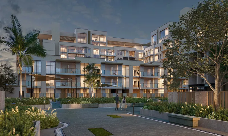 Royal Park cluster at dusk, with terraced balconies over a planted courtyard (developer render)