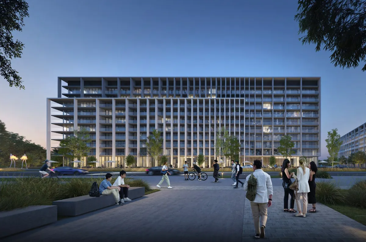 Dusk render of the Safa Parkview apartment building at Aljada seen from a paved plaza, with people walking and lit windows across the facade