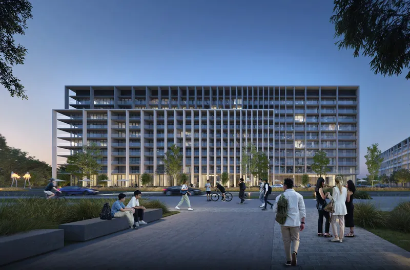 Dusk render of the Safa Parkview apartment building at Aljada seen from a paved plaza, with people walking and lit windows across the facade