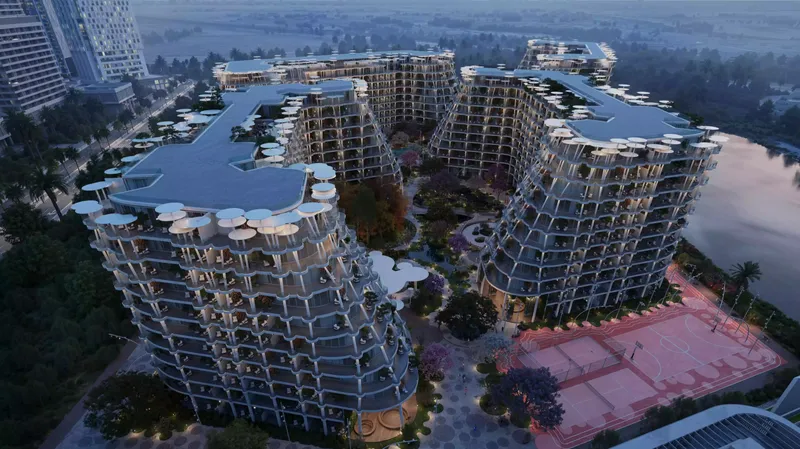 Sakura Gardens at dusk from the air, showing stepped balconies and rooftop terraces beside the lagoon