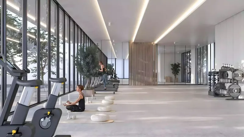 Gym at Sakura Gardens with full-height windows, exercise machines and a stretching area