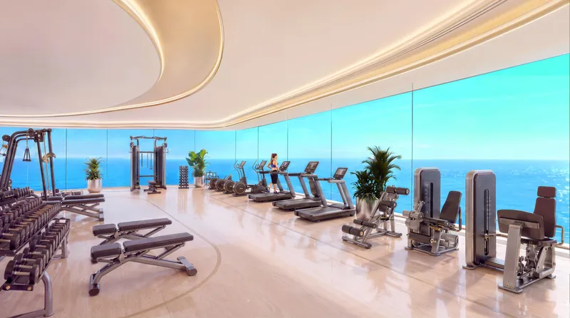 Indoor gym at Shahrukhz Residences by Danube with treadmills and weights facing the sea