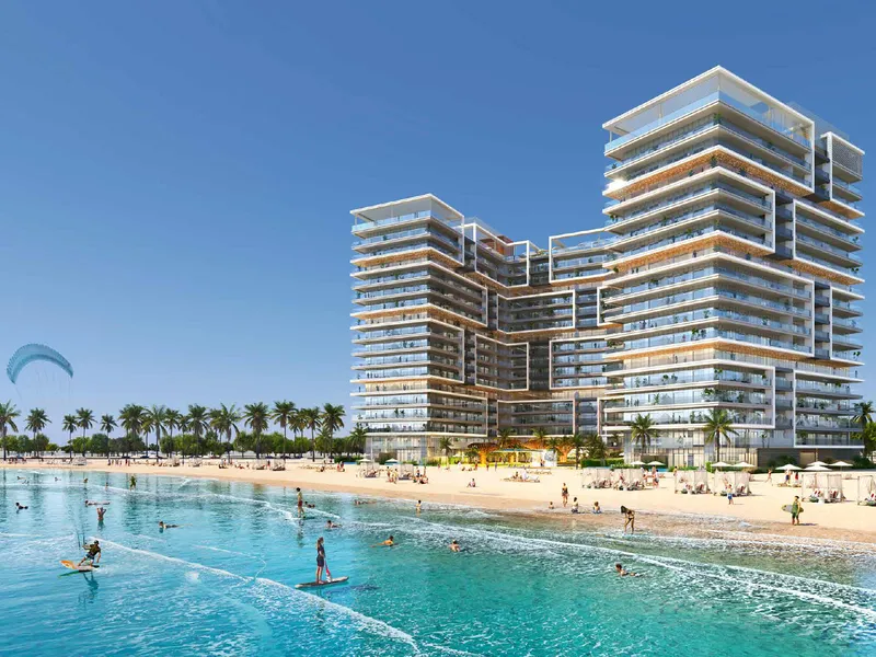 Shoreline by DAMAC seen from the sea, with its two stepped wings behind the beach on Al Marjan Island