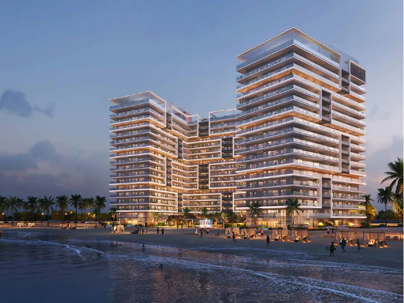 Shoreline by DAMAC lit at dusk behind the beach on Al Marjan Island