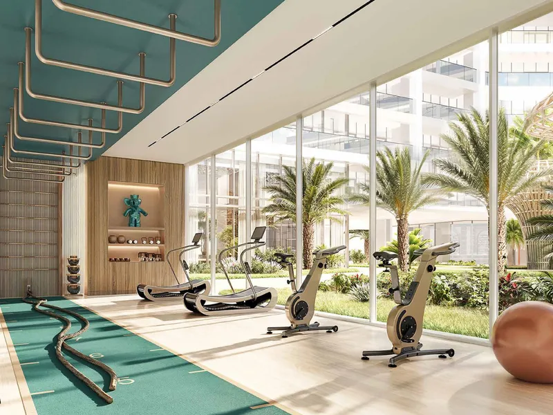 Gym at Shoreline by DAMAC with full-height glazing facing the gardens