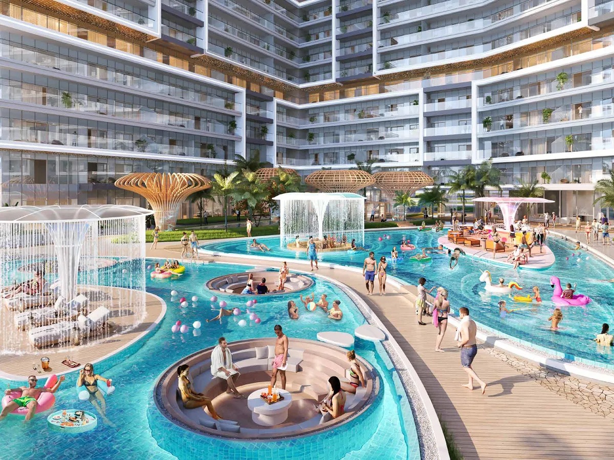 Pool deck at Shoreline by DAMAC with water features and loungers between the residential wings