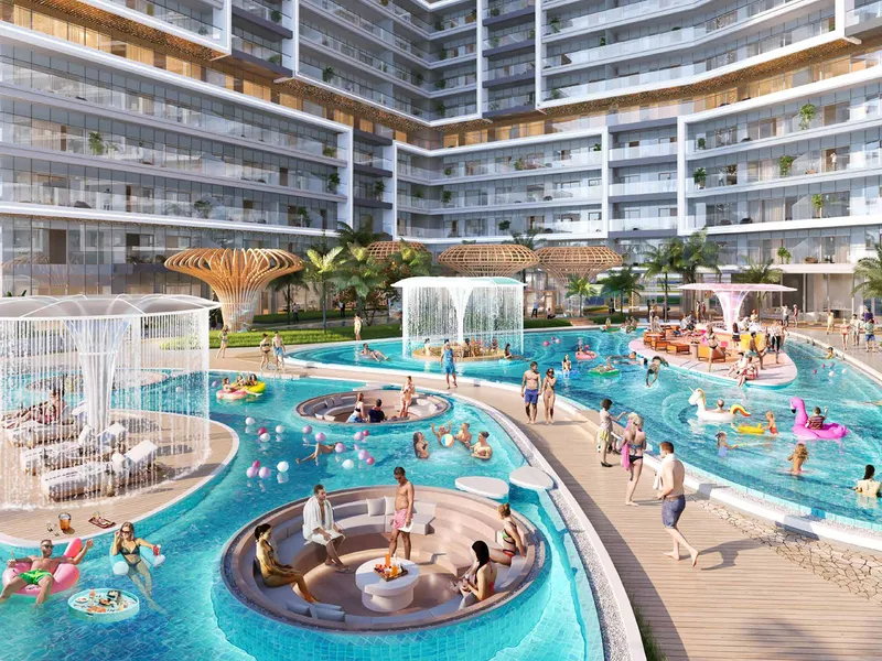 Pool deck at Shoreline by DAMAC with water features and loungers between the residential wings