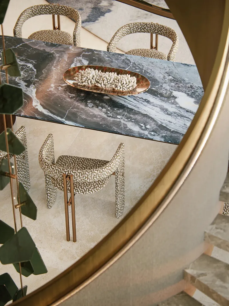 Render of a dining table in a Silena residence seen through a curved mirror