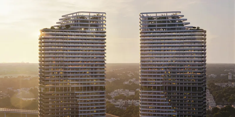 The two Skyhills Astra towers with banded balconies and stepped rooftop terraces at sunset