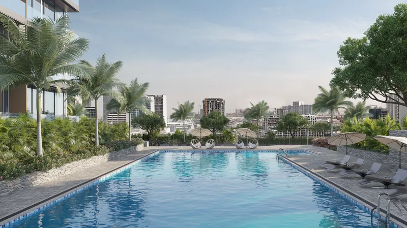 Podium swimming pool with palms and sunbeds at Skyhills Residences 3