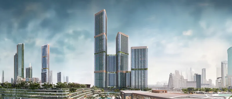 The Skyvue towers at Sobha Hartland II rising above the community's podium gardens, with the Dubai skyline behind