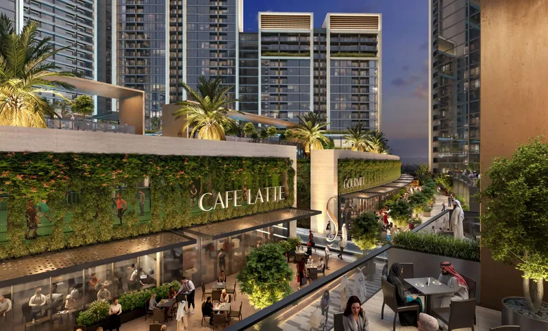 Cafés and restaurants with green walls along the Sobha Orbis dining street at dusk