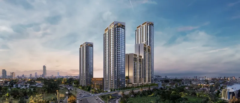 Sobha Orbis towers rising above landscaped gardens and a road interchange in Motor City, Dubai