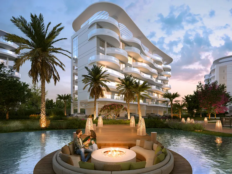 Sunken fire-pit seating on the water in front of a curved Sorrento apartment building at dusk