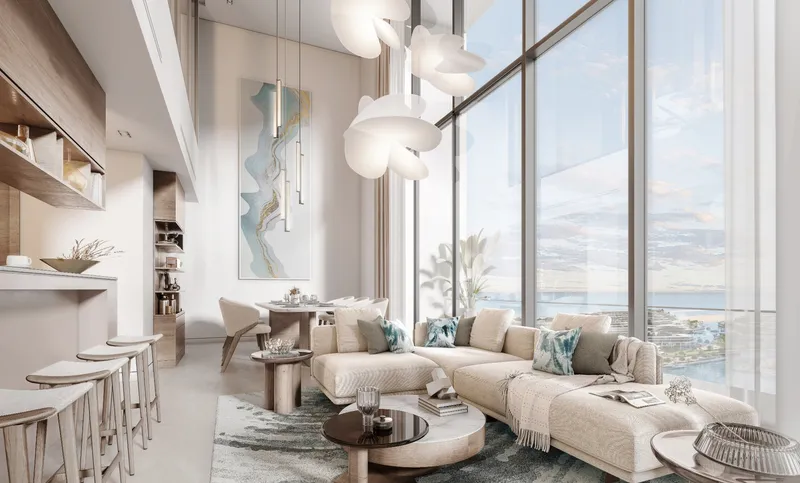 Double-height living room of a duplex at Starline Beach Residences with full-height glazing