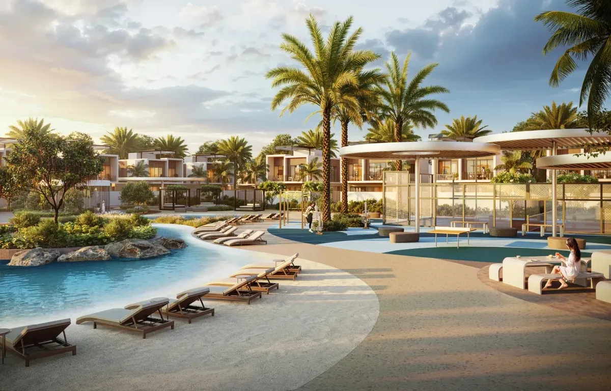 Render of the sandy lagoon beach at Sukoon, with sun loungers and a shaded clubhouse terrace