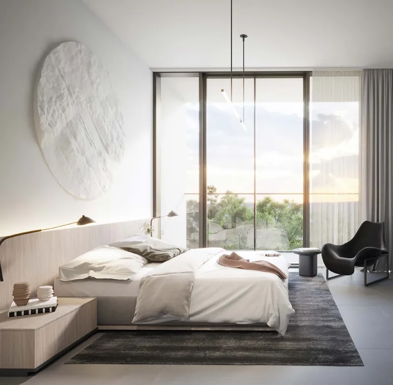 Render of an apartment bedroom at The Gate, Aljada, with a double bed, armchair and full-height window