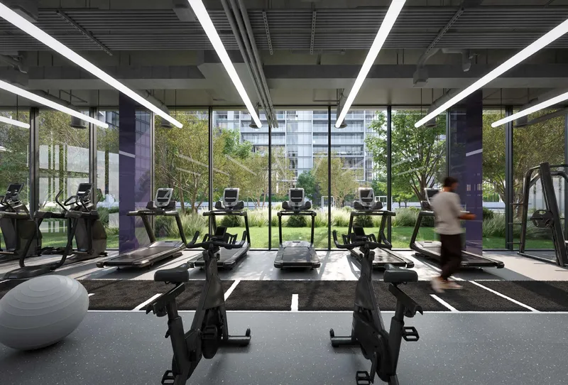 Render of the residents' indoor gym at The Gate, Aljada, with treadmills facing full-height windows onto the gardens