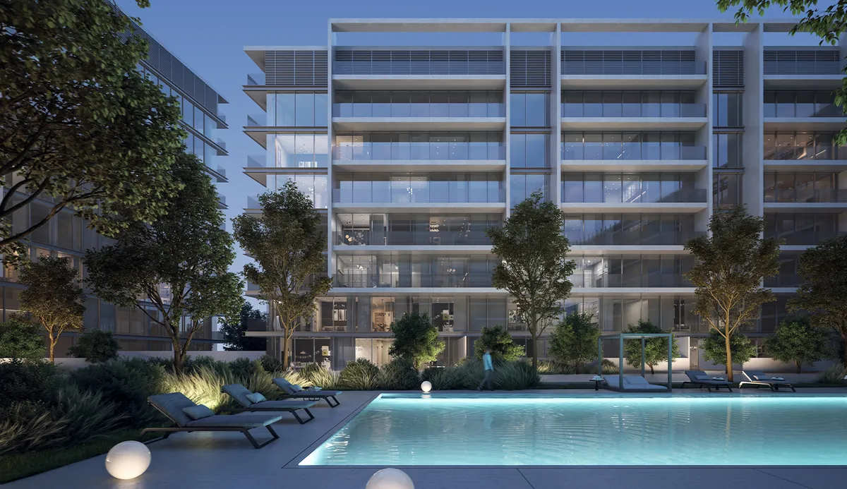 Dusk render of the residents' swimming pool at The Gate 5, Aljada, with sun loungers, planting and the lit apartment building behind