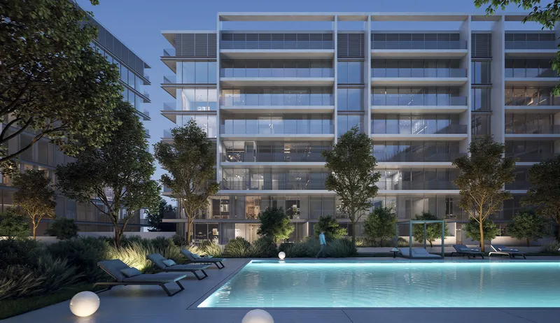 Dusk render of the residents' swimming pool at The Gate 5, Aljada, with sun loungers, planting and the lit apartment building behind
