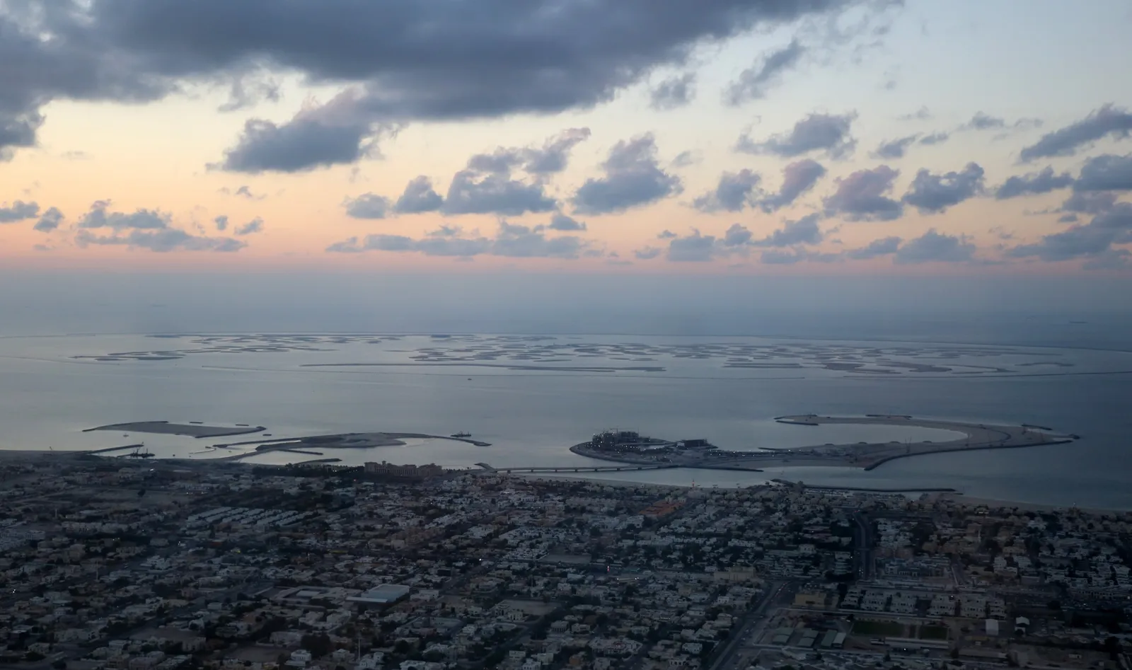 Aerial view of The World Islands off the Dubai coast, with the city skyline on the horizon