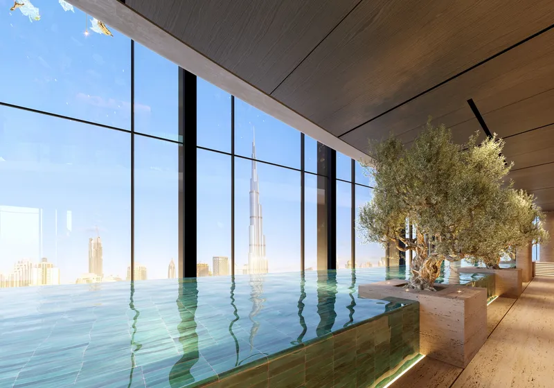 Render of the indoor infinity pool at Tiger Sky Tower with olive trees and a view of Burj Khalifa