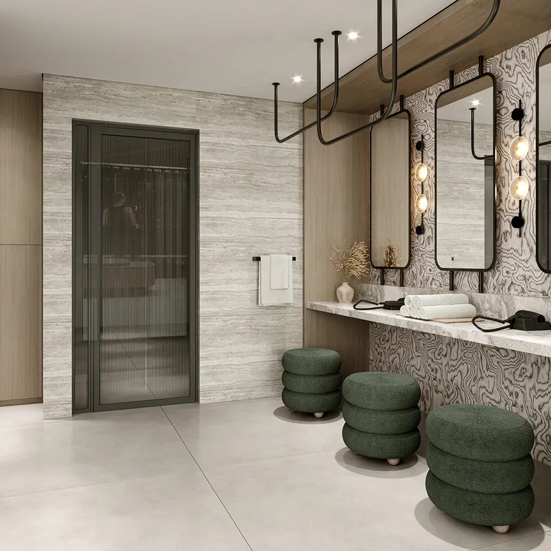 Render of a stone-clad vanity area with round mirrors and green upholstered stools at Ventone