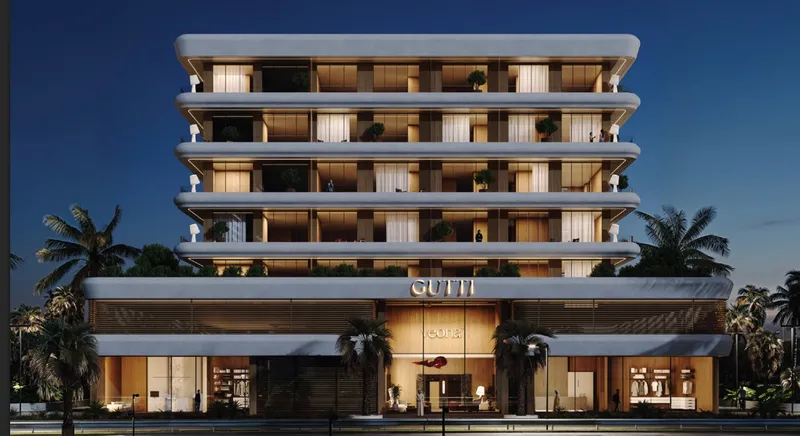 Veona by Gutti lit up at night with palm trees along the frontage