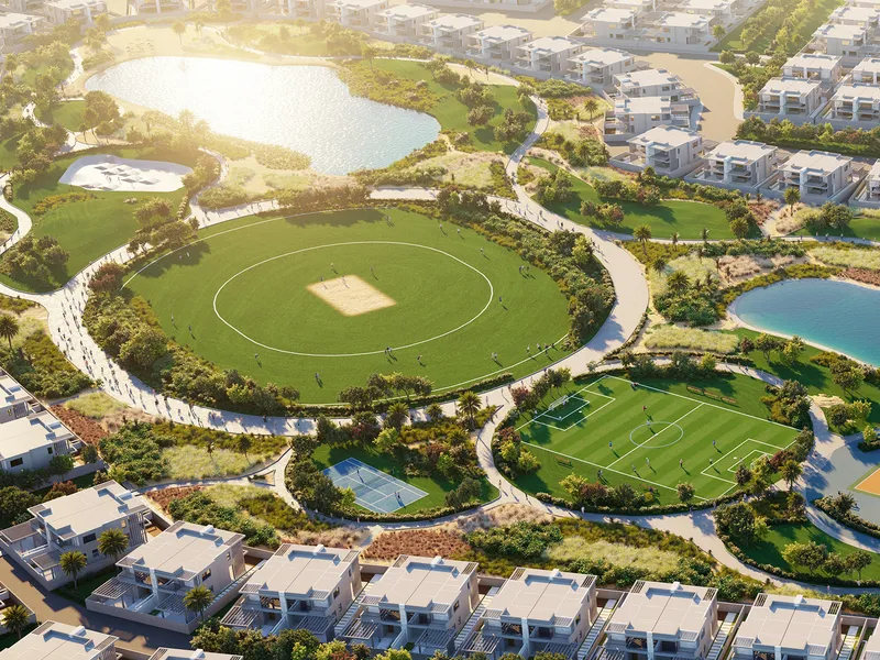 Aerial view of the cricket oval, football field and tennis court among townhouses in DAMAC Hills 2
