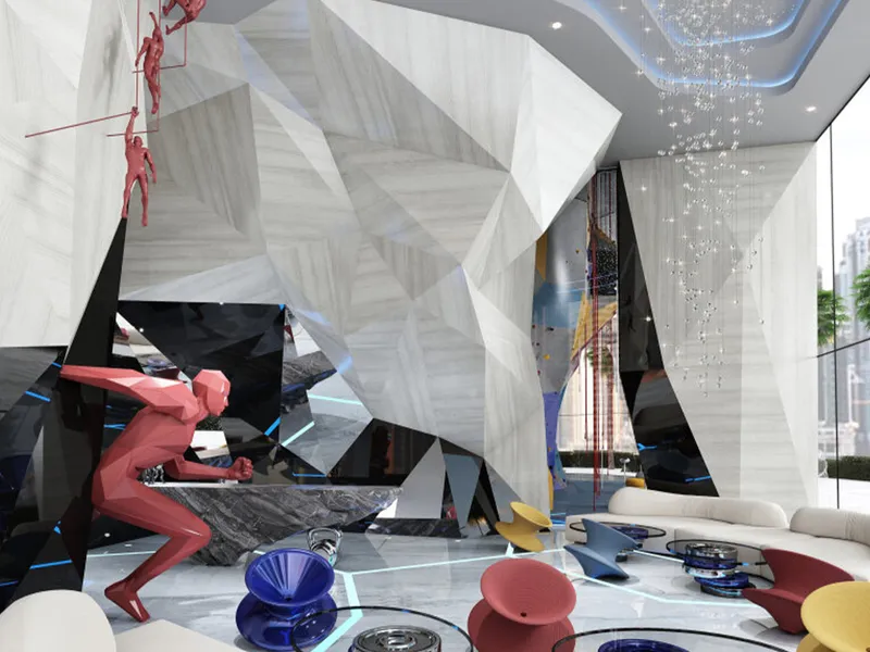 Climbing wall in the Volta lobby, with a climber on the sculpted white wall