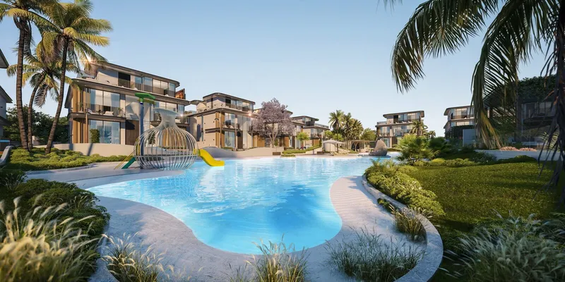 Render of the shared lagoon at Wellington Grand Villas with a water slide and villas behind palm trees