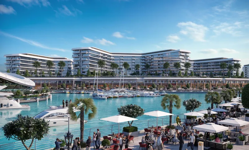 The three buildings of Yachtside Marina Residences seen across the marina from a waterside dining terrace