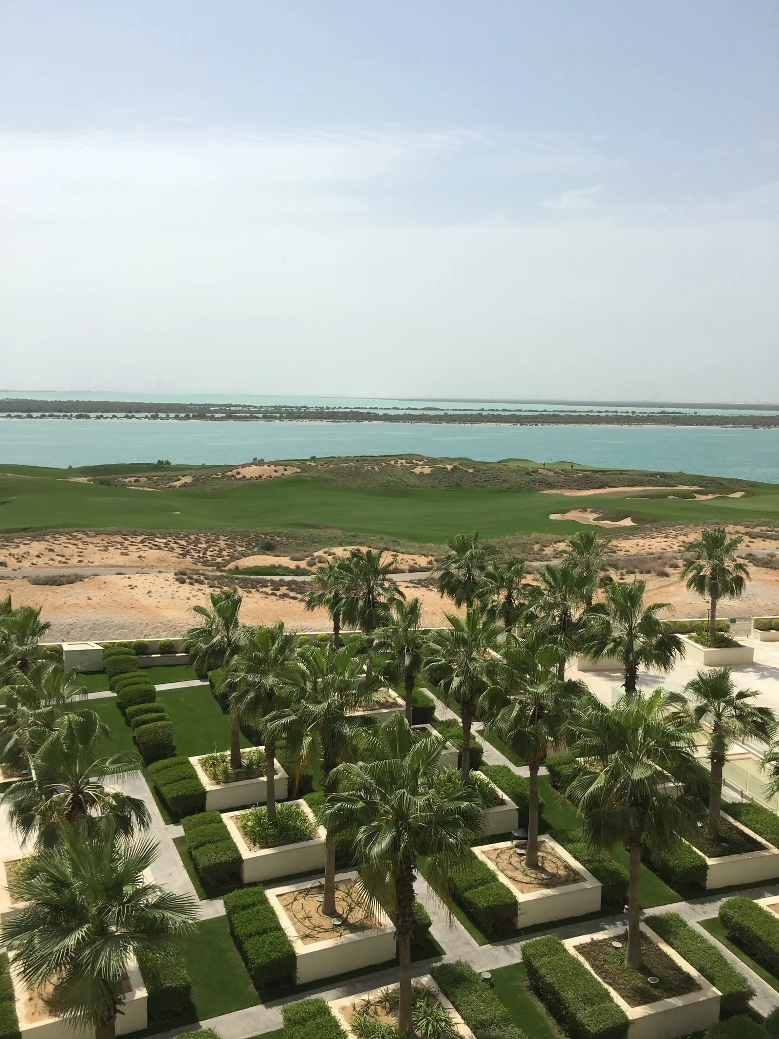 View over palm-lined gardens and a golf course to the sea on Yas Island, Abu Dhabi
