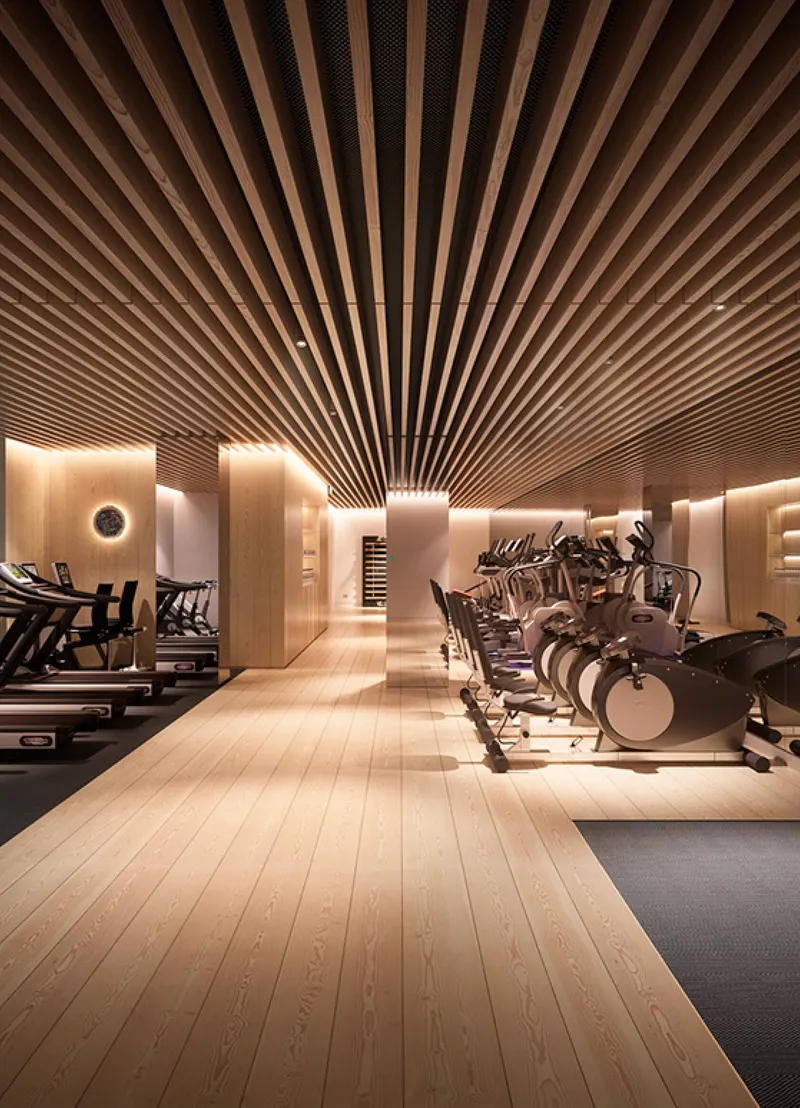 Gym at Zephyra Residences with a timber slatted ceiling and exercise bikes